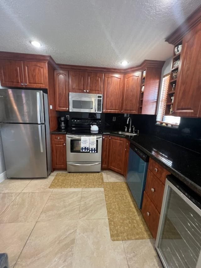 kitchen with a textured ceiling, stainless steel appliances, wine cooler, and sink