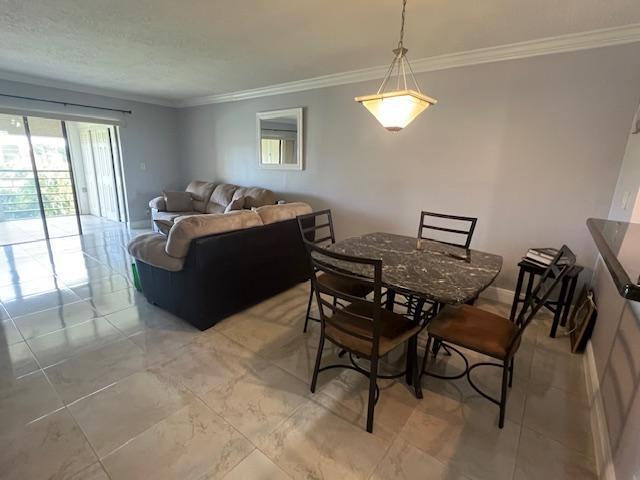 dining space featuring crown molding