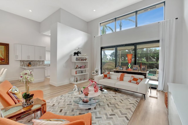 living room with a high ceiling and light wood-type flooring