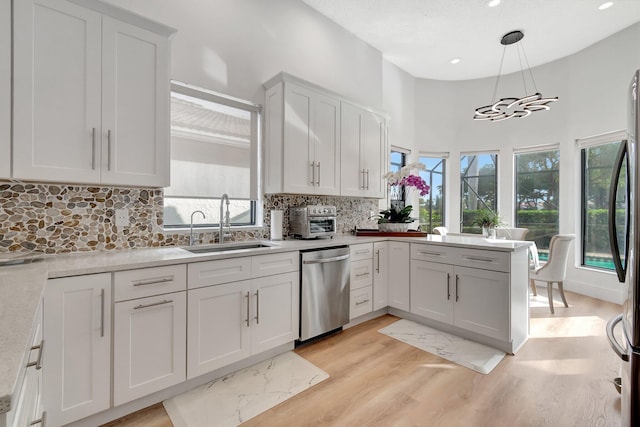 kitchen with pendant lighting, plenty of natural light, sink, and appliances with stainless steel finishes