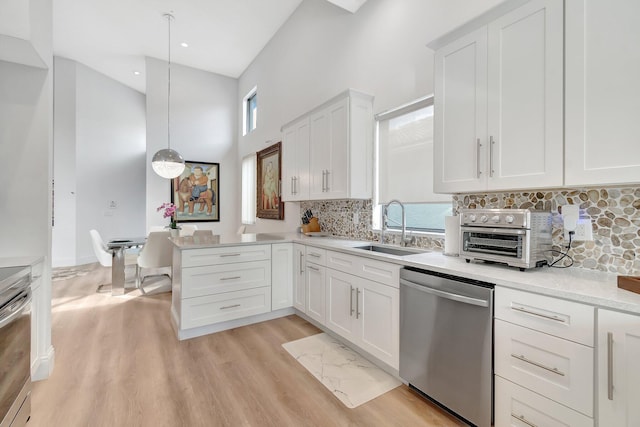 kitchen featuring a wealth of natural light, decorative light fixtures, sink, and appliances with stainless steel finishes