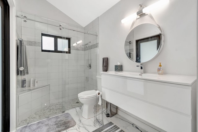 bathroom featuring a tile shower, vanity, vaulted ceiling, and toilet