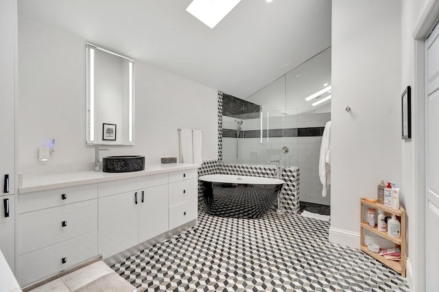 bathroom featuring plus walk in shower, vanity, and vaulted ceiling with skylight