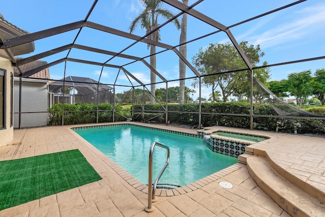 view of pool featuring glass enclosure, an in ground hot tub, and a patio area