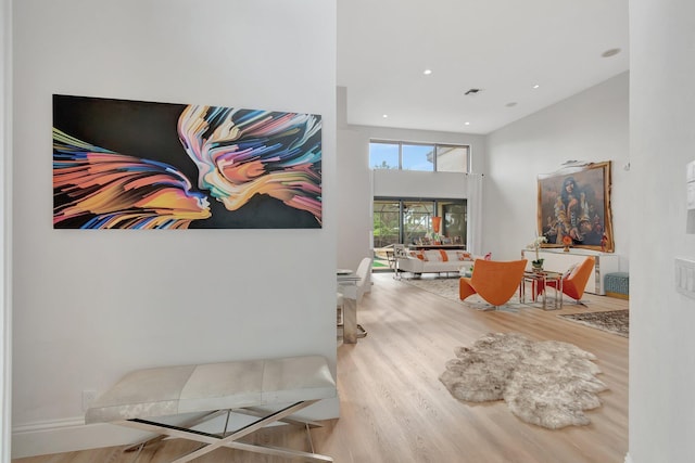 hall with hardwood / wood-style flooring and a high ceiling