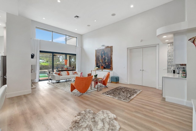 interior space featuring light hardwood / wood-style floors and a high ceiling