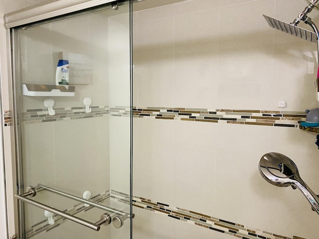 bathroom with an enclosed shower and tile walls