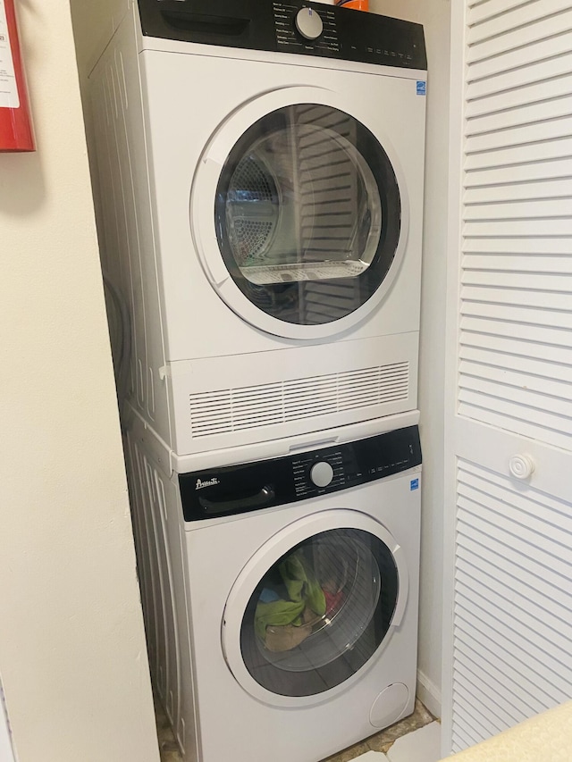 washroom featuring stacked washing maching and dryer