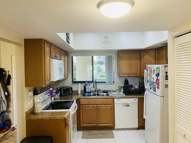 kitchen with white appliances, sink, and light tile patterned floors