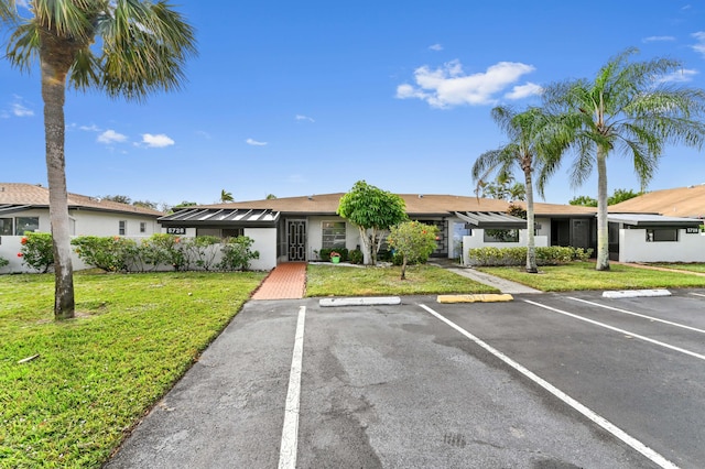 single story home with a front lawn