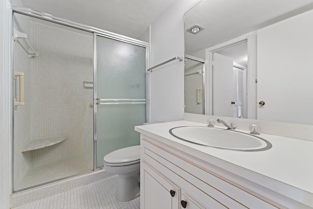 bathroom featuring toilet, vanity, tile patterned floors, and a shower with door