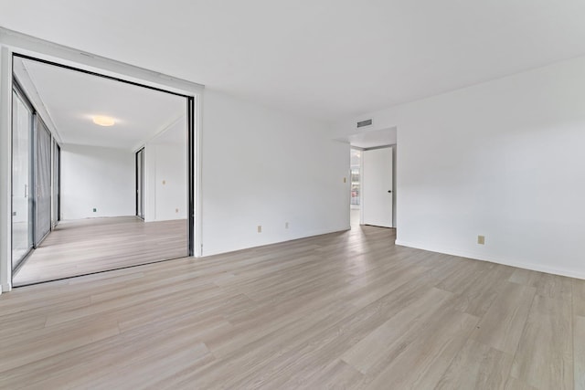 unfurnished room featuring floor to ceiling windows and light hardwood / wood-style flooring