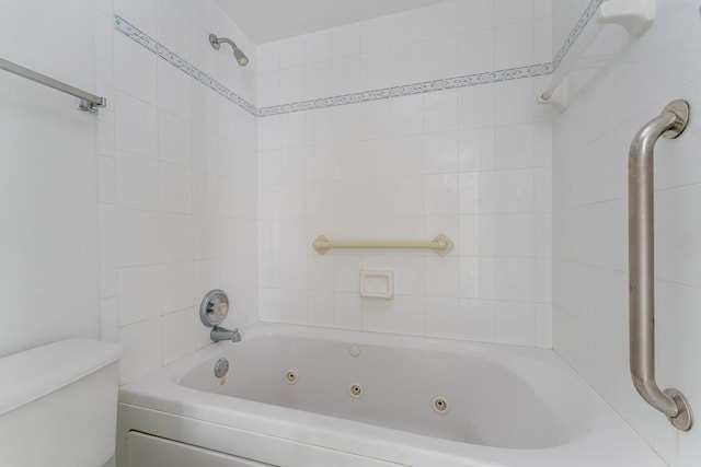 bathroom featuring tiled shower / bath combo and toilet