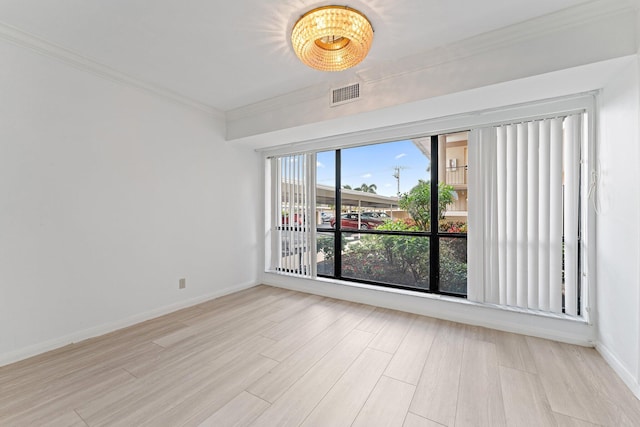 unfurnished room with light wood-type flooring and ornamental molding