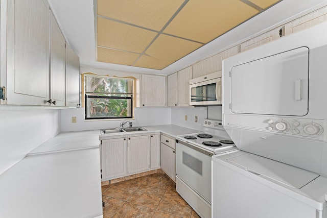 kitchen featuring white range with electric cooktop, light tile patterned flooring, sink, and stacked washer and dryer