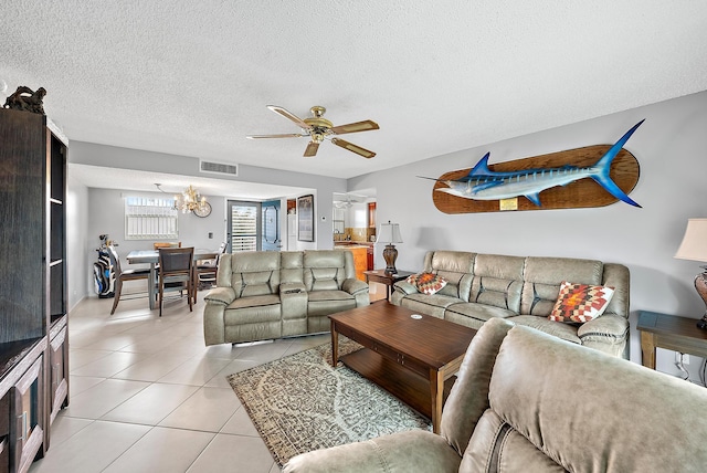 living room featuring a textured ceiling, ceiling fan with notable chandelier, and light tile patterned floors