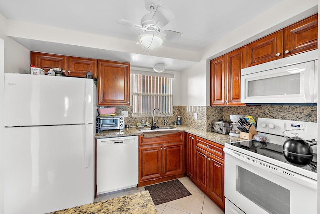 kitchen with sink, white appliances, light stone countertops, and backsplash