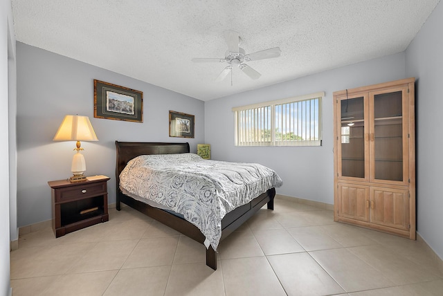 tiled bedroom with ceiling fan and a textured ceiling