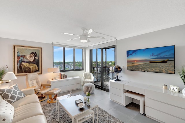 living area with a textured ceiling and a ceiling fan