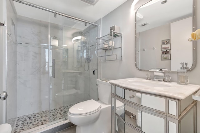 bathroom with toilet, a stall shower, visible vents, and vanity