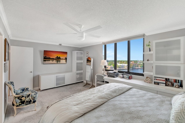 bedroom featuring ceiling fan, a textured ceiling, ornamental molding, and carpet flooring