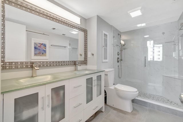 full bath with toilet, double vanity, a marble finish shower, and a sink