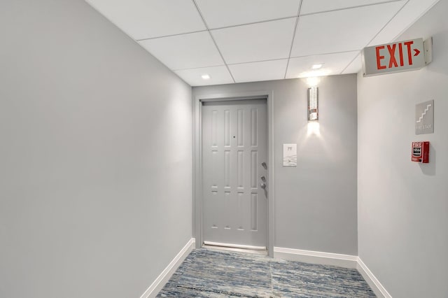 doorway to outside featuring wood finished floors, a paneled ceiling, and baseboards