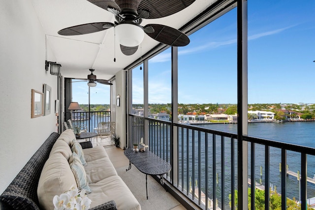 sunroom / solarium featuring a water view and a ceiling fan