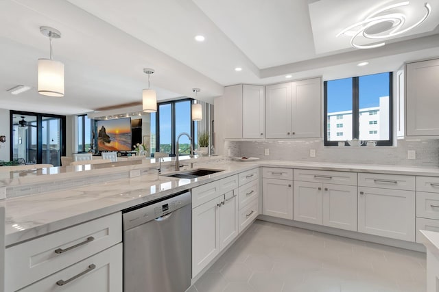 kitchen with backsplash, white cabinetry, a sink, light stone countertops, and dishwasher