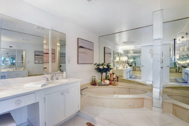 bathroom with tile patterned flooring, vanity, and a relaxing tiled tub