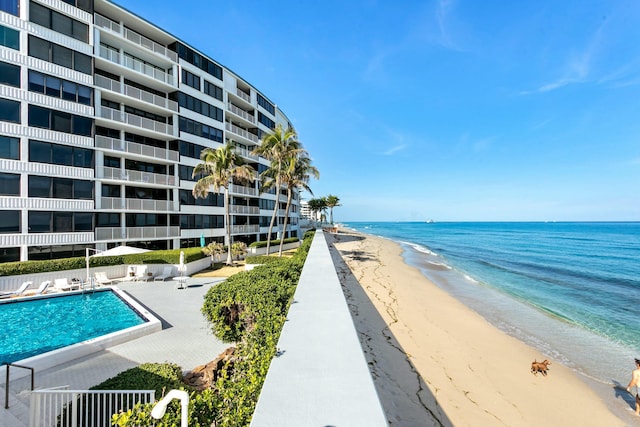 view of pool featuring a beach view and a water view