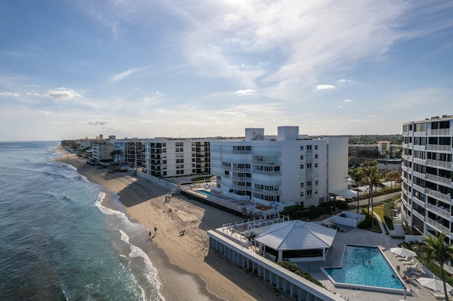 birds eye view of property featuring a water view and a beach view