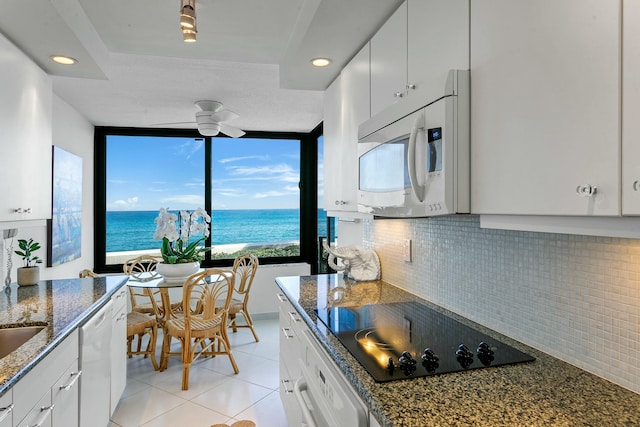 kitchen featuring a water view, white cabinetry, and black electric cooktop