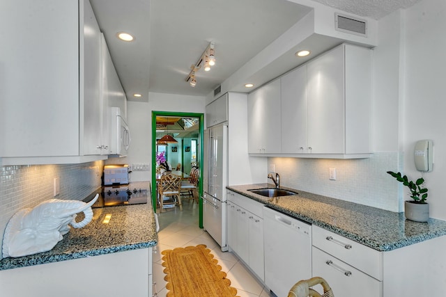 kitchen with sink, light tile patterned floors, backsplash, white appliances, and white cabinets