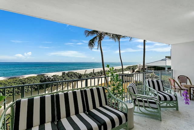 balcony featuring a beach view and a water view