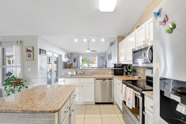 kitchen featuring white cabinets, a center island, sink, and appliances with stainless steel finishes