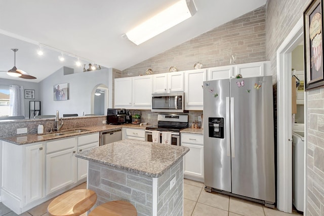 kitchen featuring kitchen peninsula, stainless steel appliances, white cabinets, and sink