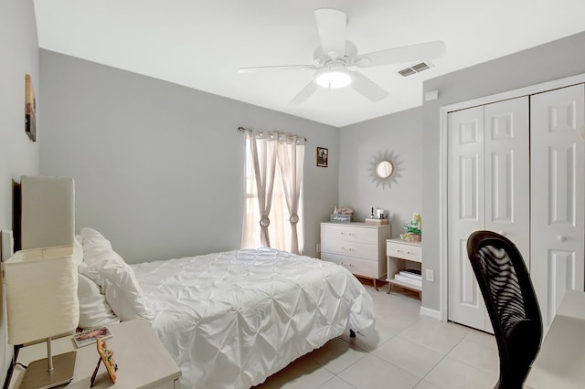 tiled bedroom featuring ceiling fan and a closet