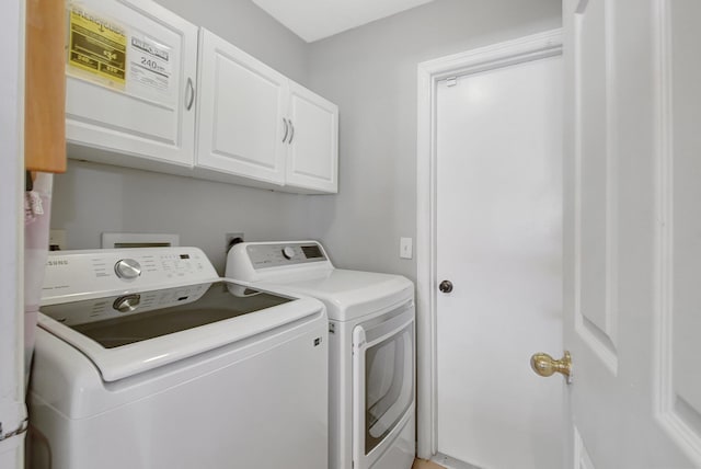 washroom with cabinets and washing machine and clothes dryer