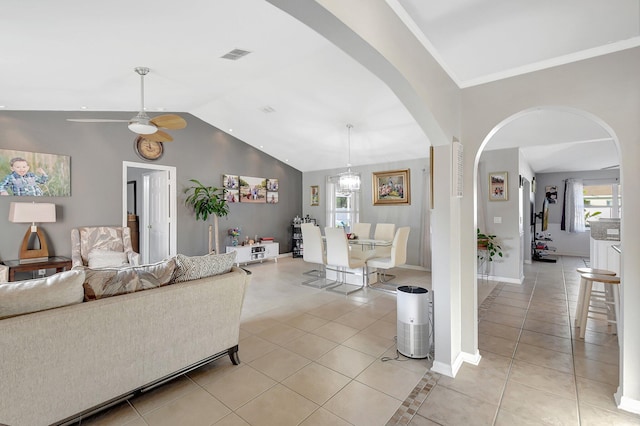 tiled living room with ceiling fan and vaulted ceiling