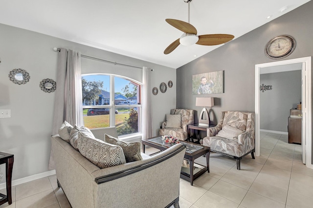 living room featuring ceiling fan, light tile patterned floors, and vaulted ceiling