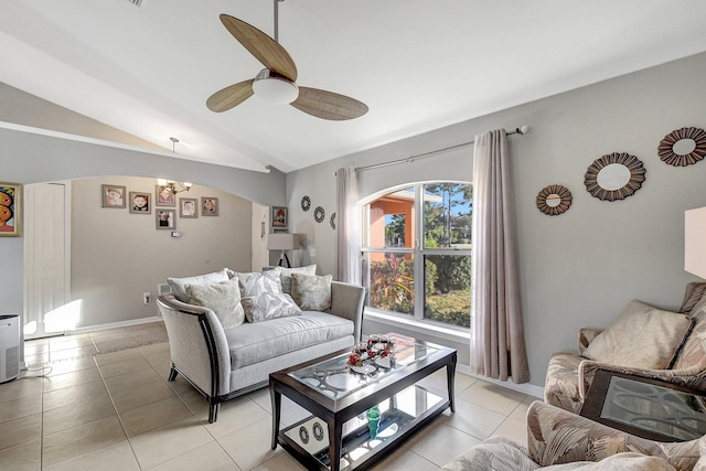 tiled living room with ceiling fan with notable chandelier and lofted ceiling