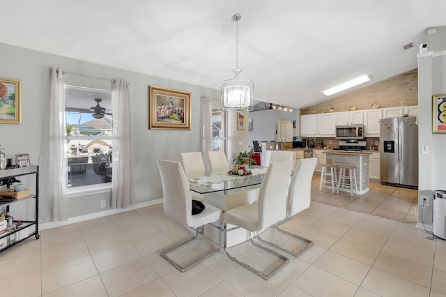 dining room featuring light tile patterned floors, ceiling fan with notable chandelier, vaulted ceiling, and sink