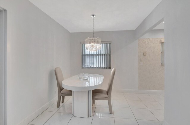 tiled dining area featuring a chandelier