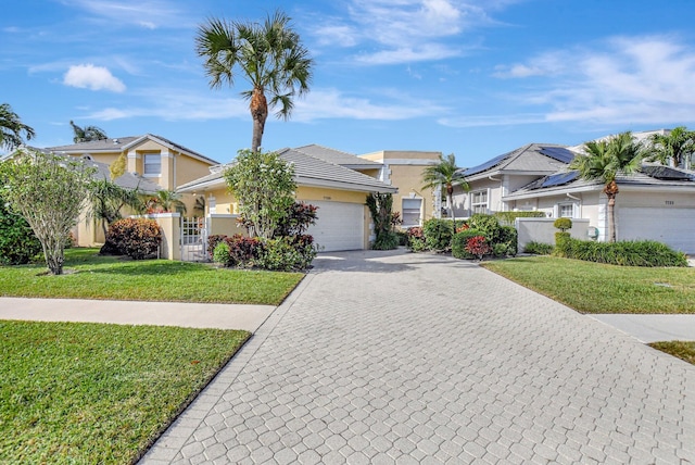 ranch-style home with a garage and a front lawn