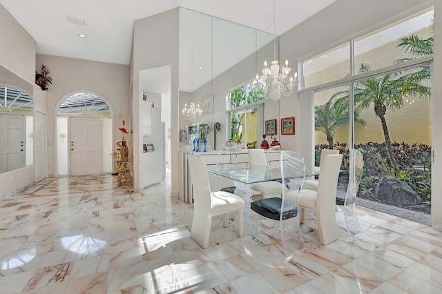 dining room featuring a towering ceiling and an inviting chandelier