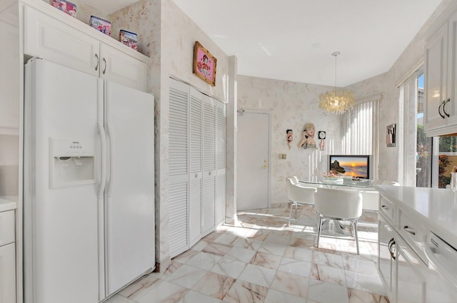 kitchen featuring white cabinets, white appliances, and an inviting chandelier