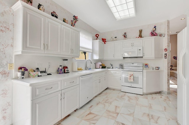 kitchen featuring white appliances, white cabinetry, and sink