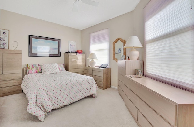 bedroom with ceiling fan and light colored carpet