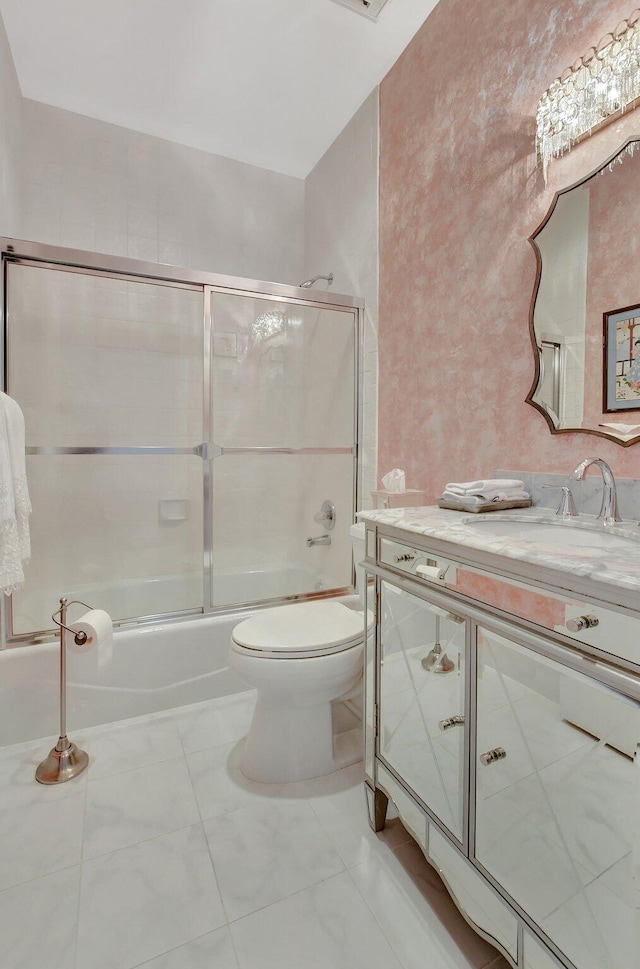 full bathroom featuring vanity, toilet, and combined bath / shower with glass door